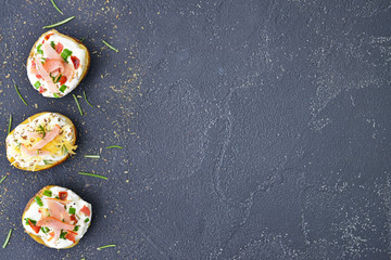 Tasty baked potato with sour cream on dark background