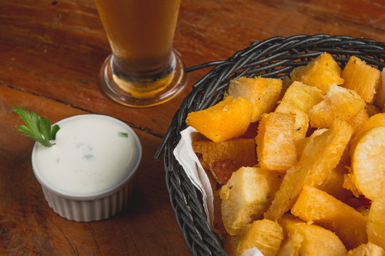 Comida de boteco brasileira mandioca frita servida em tigela em balc&atilde;o de boteco