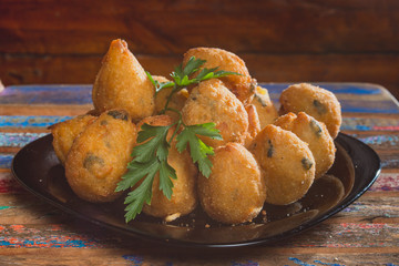 Comida de boteco brasileira salgados diversos servidos em tigelas em balcão de boteco: pastel, bolinha de queijo, coxinha e quibe