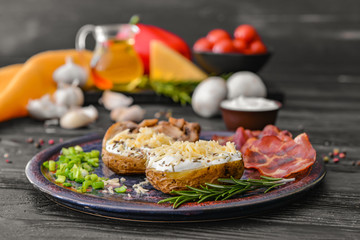 Tasty baked potato with sour cream, mushrooms and bacon on table