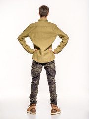 Back view of an young man in camouflage clothing. Rookie in army clothes. Teenager in khaki military clothing