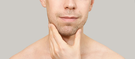 Fototapeta premium Man hold chin. Hand near male face. Think concept. Happy person. Close up. Casual home skin care routine. Healthcare facial treatment. Cute people standing. Mirror interesting