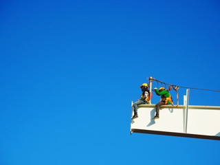 Man Working on the Working at height on construction site with blue sky