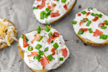 Tasty baked potato with sour cream on parchment