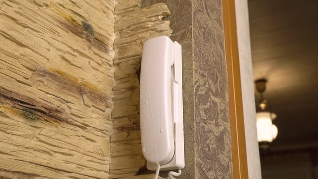 close-up cleaning, disinfection, wiping of the intercom handset on-door speakerphone with a gloved hand and a napkin