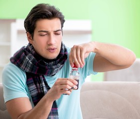 Young handsome man suffering from illness at home