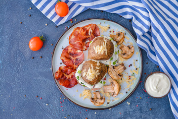 Tasty baked potato with sour cream, bacon and mushrooms on color background