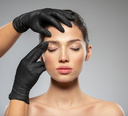 Face skin check before plastic surgery. Beautician touching woman face. Doctor checks a skin before...