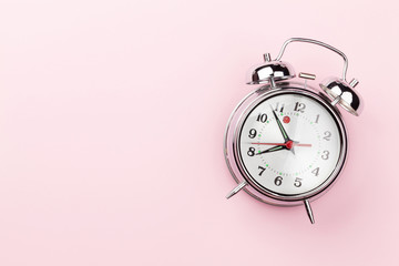 Pink workplace with alarm clock