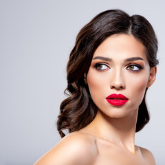 Beautiful young fashion woman with red lipstick.  Brunette woman with a clean skin of face. Portrait of model with bright red lips. Glamour fashion model with bright gloss make-up  posing at studio.