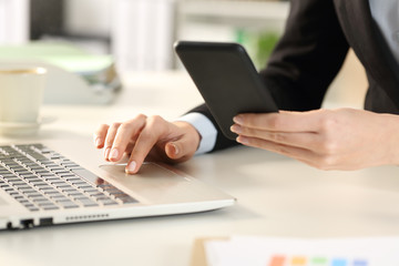 Executive hands using phone and laptop at office
