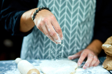 The chef cooks the dough sprinkled with flour freezing in motion