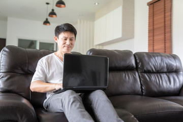 Business man working on laptop computer at home during quarantine for coronavirus. Work from home and social distancing concept.