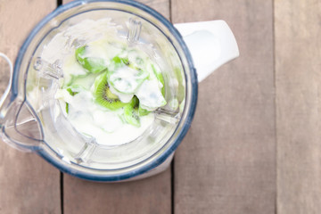 Fresh sliced kiwi fruit on electric equipment juice Yogurt smoothie ingredients and blender. Top view