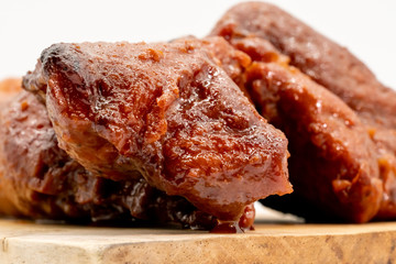 Roasted BBQ red pork in Chinese style on wooden cutting board isolated on white background