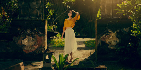 A girl in a white dress. Travel to Bali. Authentic architecture. Travel. Cinematic grading.