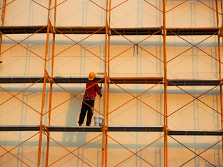 Man Working on the Working at height on construction site with blue sky