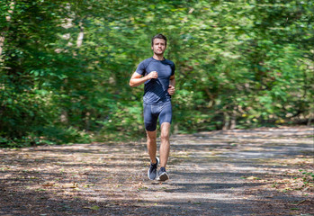 sport young man running in the forest . runner exercise in nature Healthy lifestyle . training and...