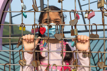 An 8 year old girl wears a mask during the coronavirus pandemic as she practices social distancing.