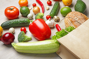 Paper bag with healthy products on wooden background
