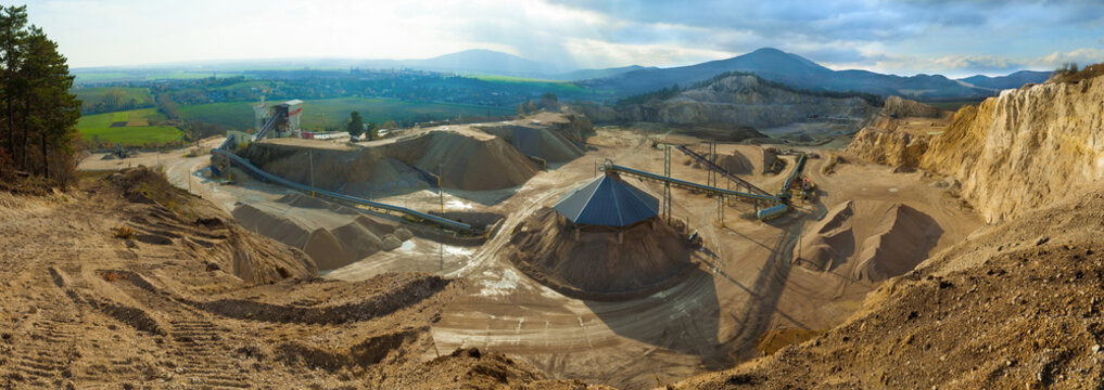 Stone pit in the mountains near the village. Panoramatic view of stone quarry in forest. Stone-pit in the wood. Forest quarry. Open-pit mine. Quarrying industry