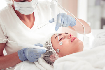 Beauty expert using new equipment for deep facial cleansing