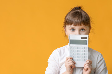 Little girl with calculator on color background