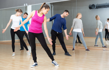 Fototapeta na wymiar Females and males stretching at dance class