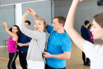 Mature dancing couple during group class