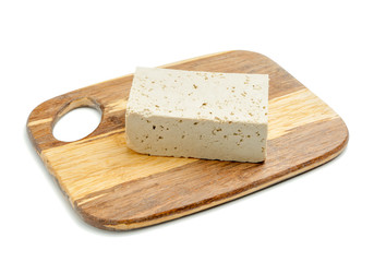 Board with tasty tofu cheese on white background