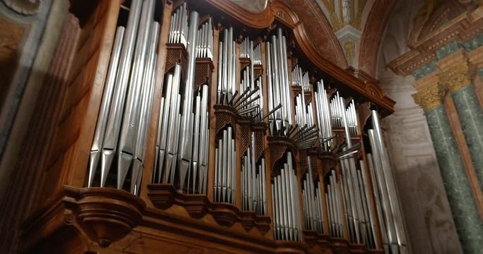 A man plays a church organ, an organ in a beautiful Italian church