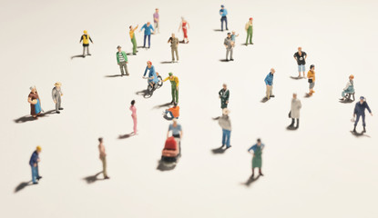 Top view of people (miniature toys) with long shadows keep distance away in public during sunrise...