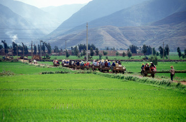 Villagers escape traffic jam down side road in Dali, Yunnan Province, People's Republic of China