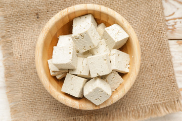 Bowl with tasty tofu cheese on table