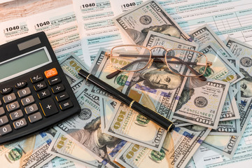 1040 tax form on desk with pen calculator and us dollar. business concept