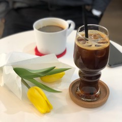 cup of coffee with yellow tulips