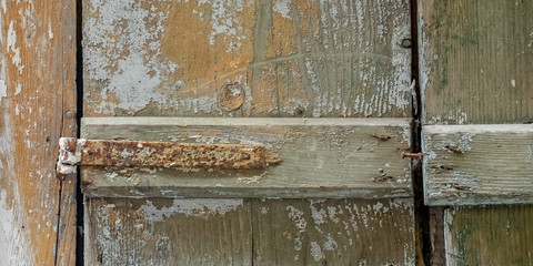partial view of old weathered window shutters and rusty hinge