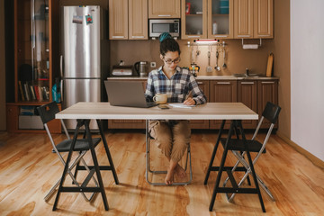 Young woman working home at the kitchen during self-isolation