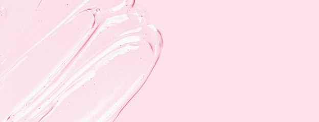 Serum texture, clear liquid gel with bubbles. Pink cosmetic skin care product sample. Hand...
