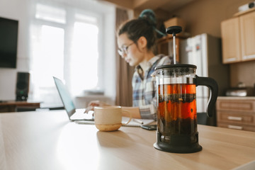 Hot tea on the background of a person working at a computer - Powered by Adobe