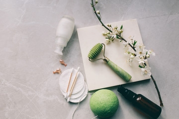 Dermaroller and serum next to an anti aging face cream Beauty industry  Dermaroller for medical micro needling therapy Derma roller mesoroller for mesotherapy on a light background near flowers