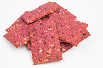heap of crunchy beetroot cracker with sunflower, poppy and sorghum seeds