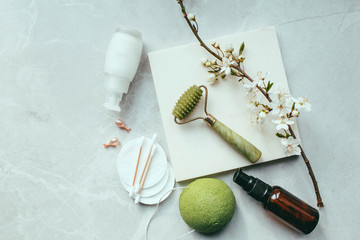 Dermaroller and serum next to an anti aging face cream Beauty industry  Dermaroller for medical micro needling therapy Derma roller mesoroller for mesotherapy on a light background near flowers