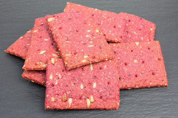 heap of crunchy beetroot cracker with sunflower, poppy and sorghum seeds