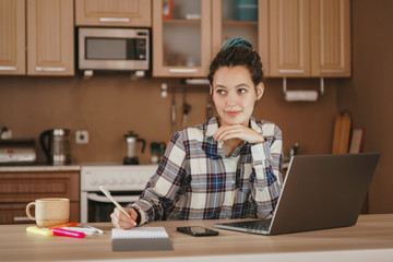 Girl thinking working with laptop at home. Self-isolation, working from home.