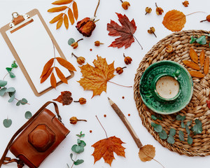 Trendy flat lay composition with coffee cup, old retro camera and autumn leaf, Office table with clip board, blogger concept