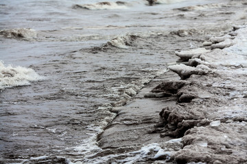 Coast, tide of water. Beautiful background with the coast, strong waves and rough coastline.