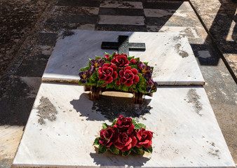 Künstliche Blumen auf Keramik auf einem Friedhof in Spanien