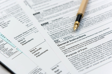 1040 tax form with pen, finance document