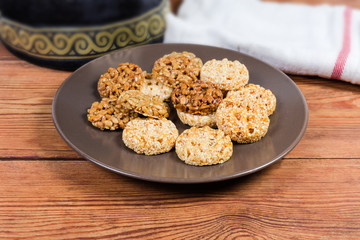 Round sesame and sunflower seed candies on dish close-up